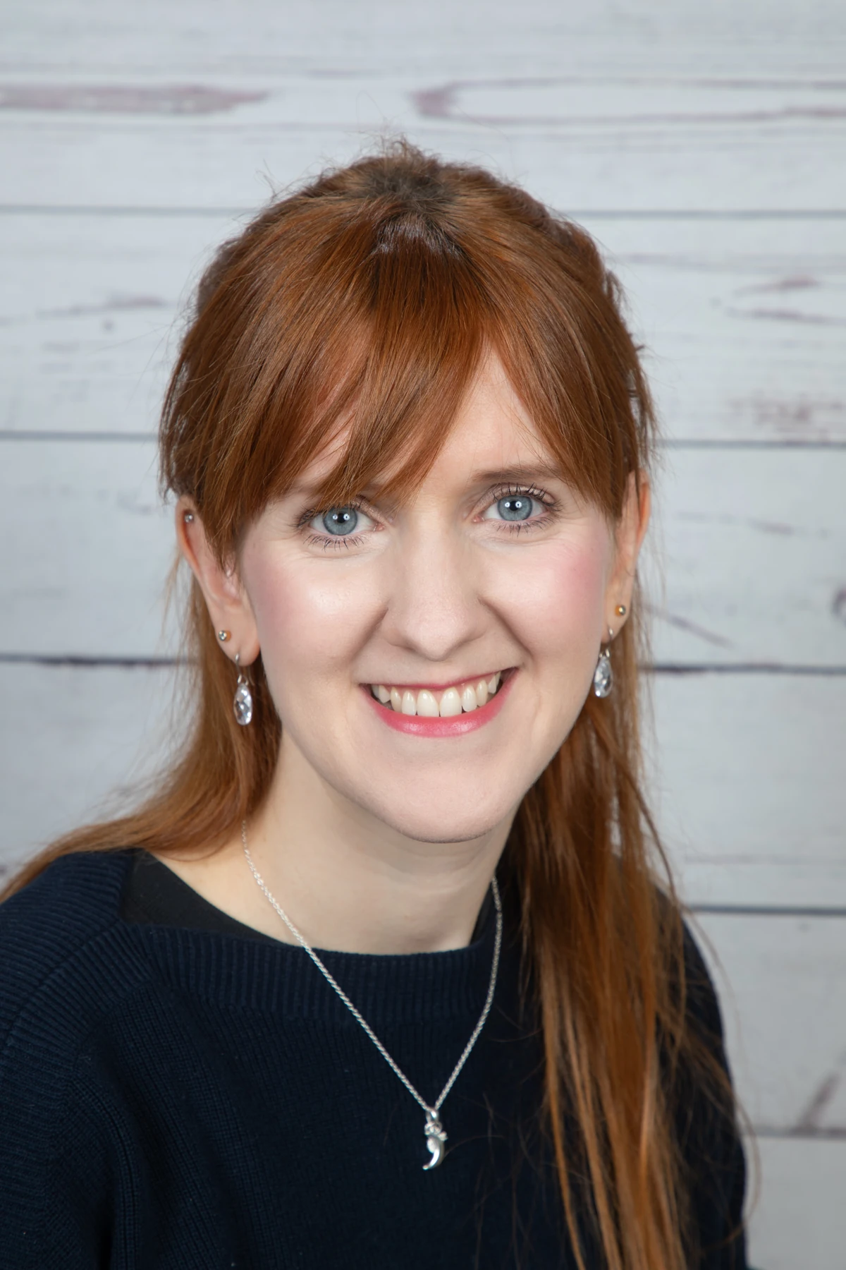Stéphanie Richter lächelt vor einem hellen Holzhintergrund